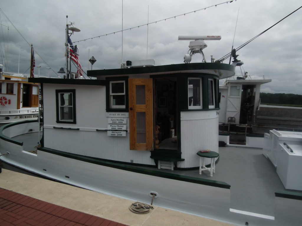 Dave Wright, owner of the Prop Wash, displays prior names of the historic oyster Buyboat next to the pilot house of the vessel.  THE CHESAPEAKE TODAY photo