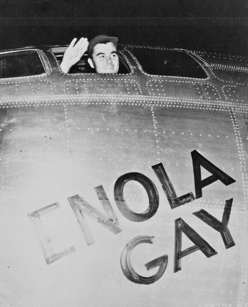 Col. Paul W. Tibbets, Jr., pilot of the ENOLA GAY, the plane that dropped the atomic bomb on Hiroshima, waves from his cockpit before the takeoff, 6 August 1945